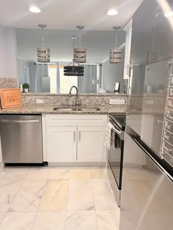 a kitchen with stainless steel appliances granite countertop a sink stove and cabinets