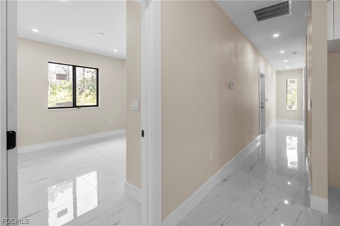 526 Knapp Street Lehigh Acres, FL 33974 - Photo 29 of 37 a view of hallway with windows and chandelier