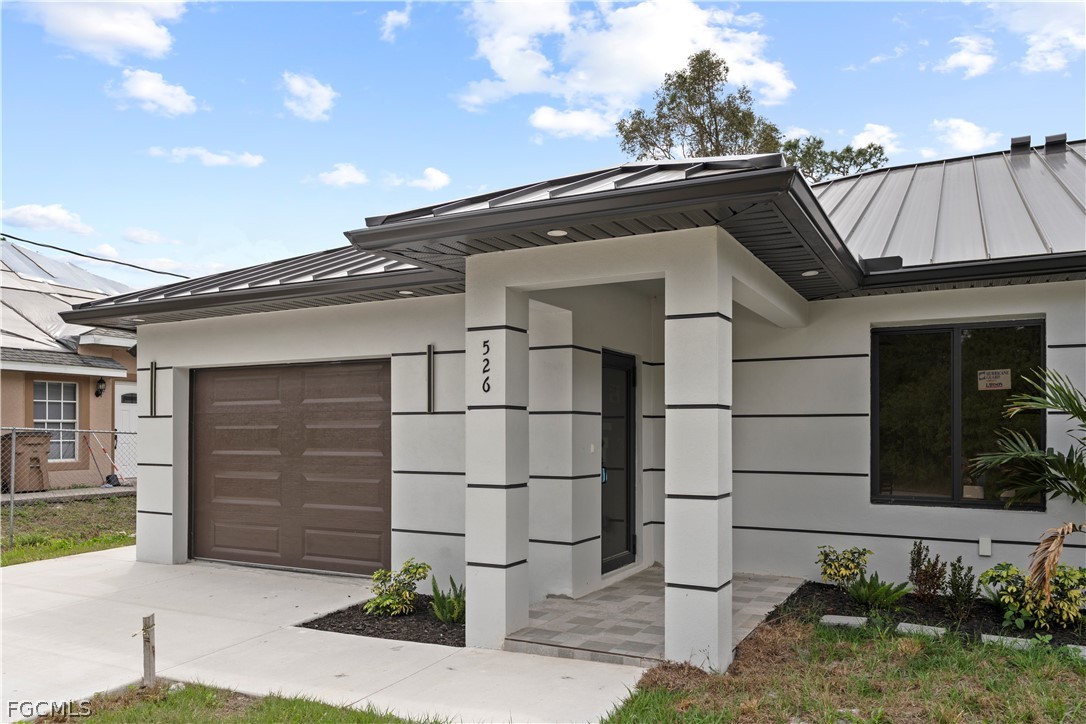 526 Knapp Street Lehigh Acres, FL 33974 - Photo 6 of 37 a white building with a outdoor space
