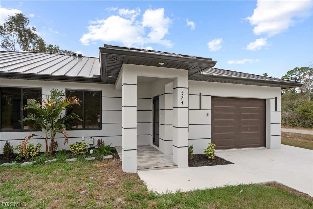 526 Knapp Street Lehigh Acres, FL 33974 - Photo 7 of 37 a front view of a house with garden