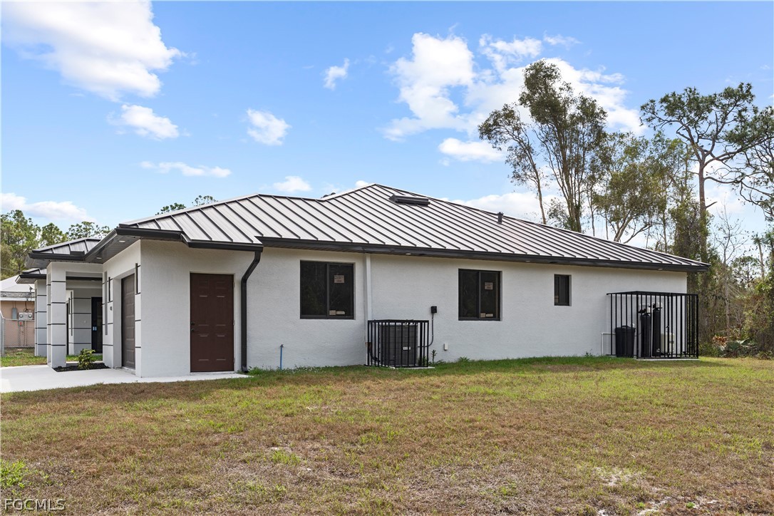 526 Knapp Street Lehigh Acres, FL 33974 - Photo 8 of 37 a view of a house with a yard and garage