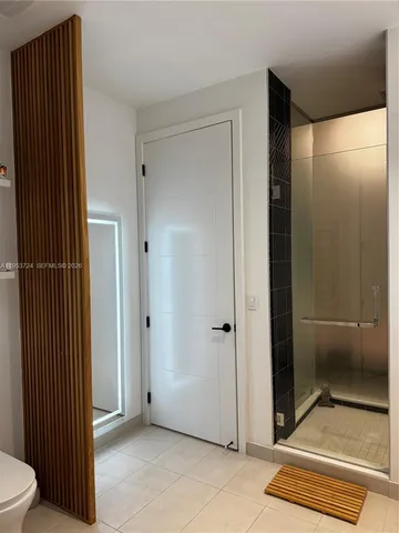 a view of a bathroom with a glass door shower and a toilet