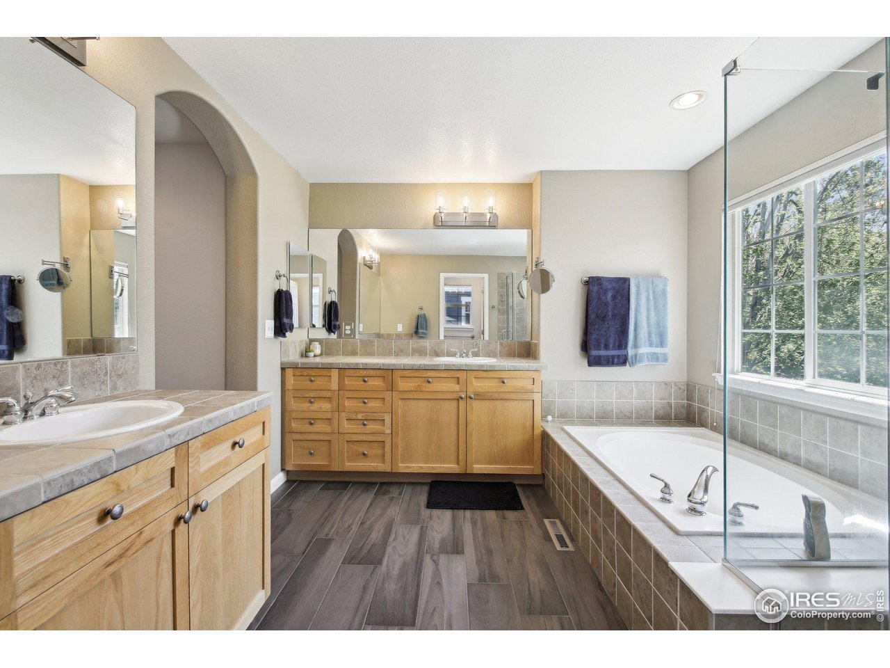 4109 Frederick Circle Longmont, CO 80503 - Photo 26 of 40 a bathroom with a granite countertop sink mirror bathtub and window