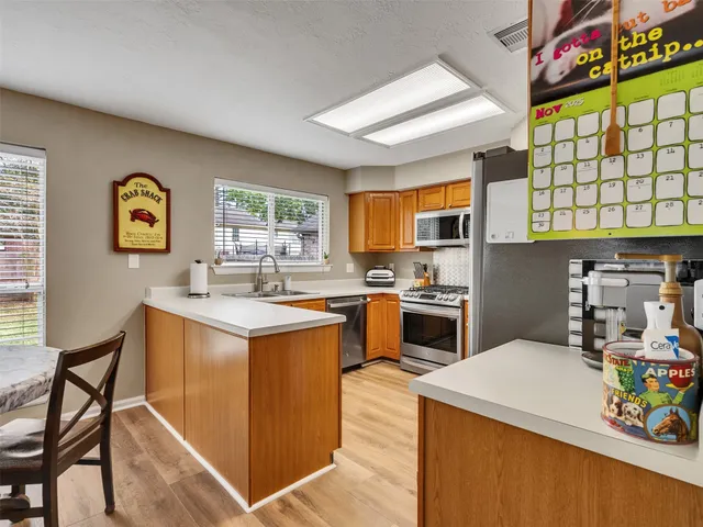 a kitchen with stainless steel appliances granite countertop a stove a sink dishwasher and a refrigerator