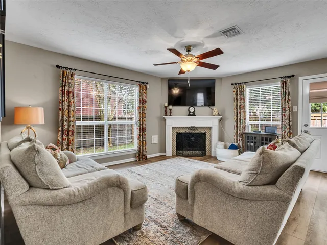 a living room with furniture a fireplace and a large window
