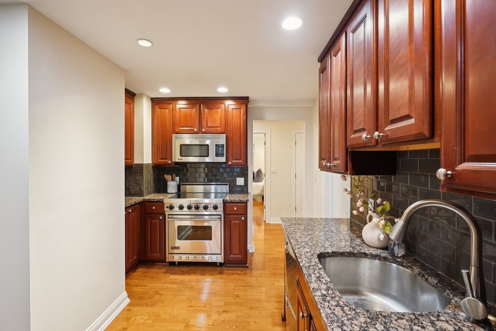 20 Chapel Street, Unit B811 Brookline, MA 02446 - Photo 13 of 33 a kitchen with stainless steel appliances granite countertop a sink a stove and a refrigerator