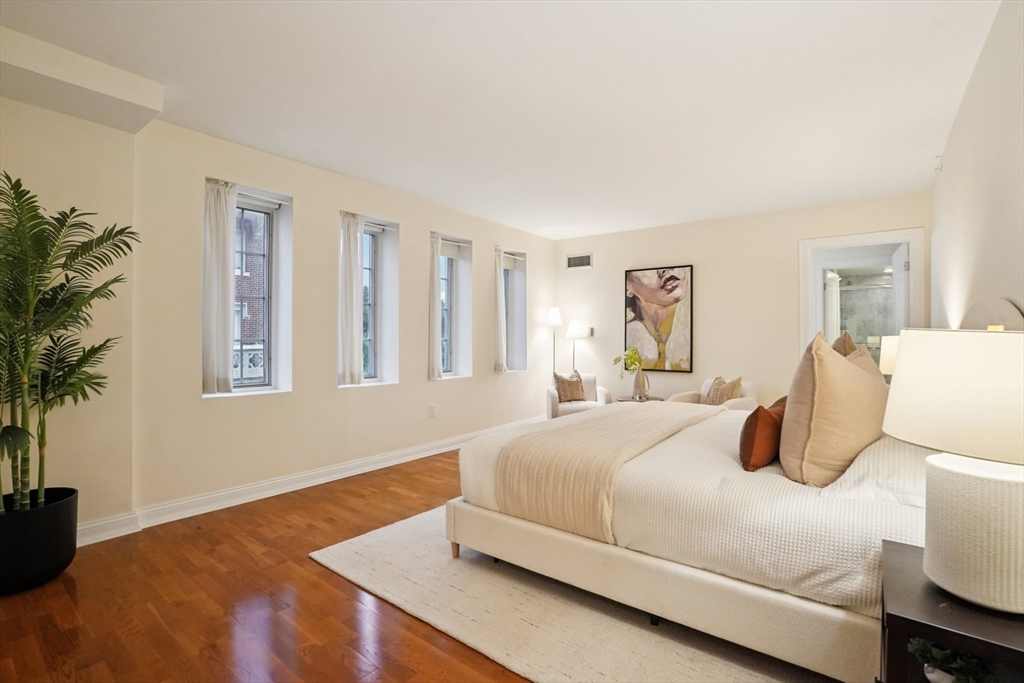 20 Chapel Street, Unit B811 Brookline, MA 02446 - Photo 30 of 33 a bedroom with a large bed and a potted plant