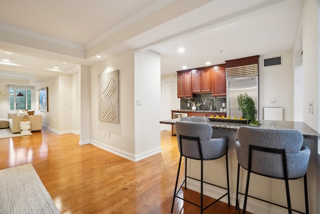 20 Chapel Street, Unit B811 Brookline, MA 02446 - Photo 10 of 33 a kitchen with a table chairs refrigerator and couch