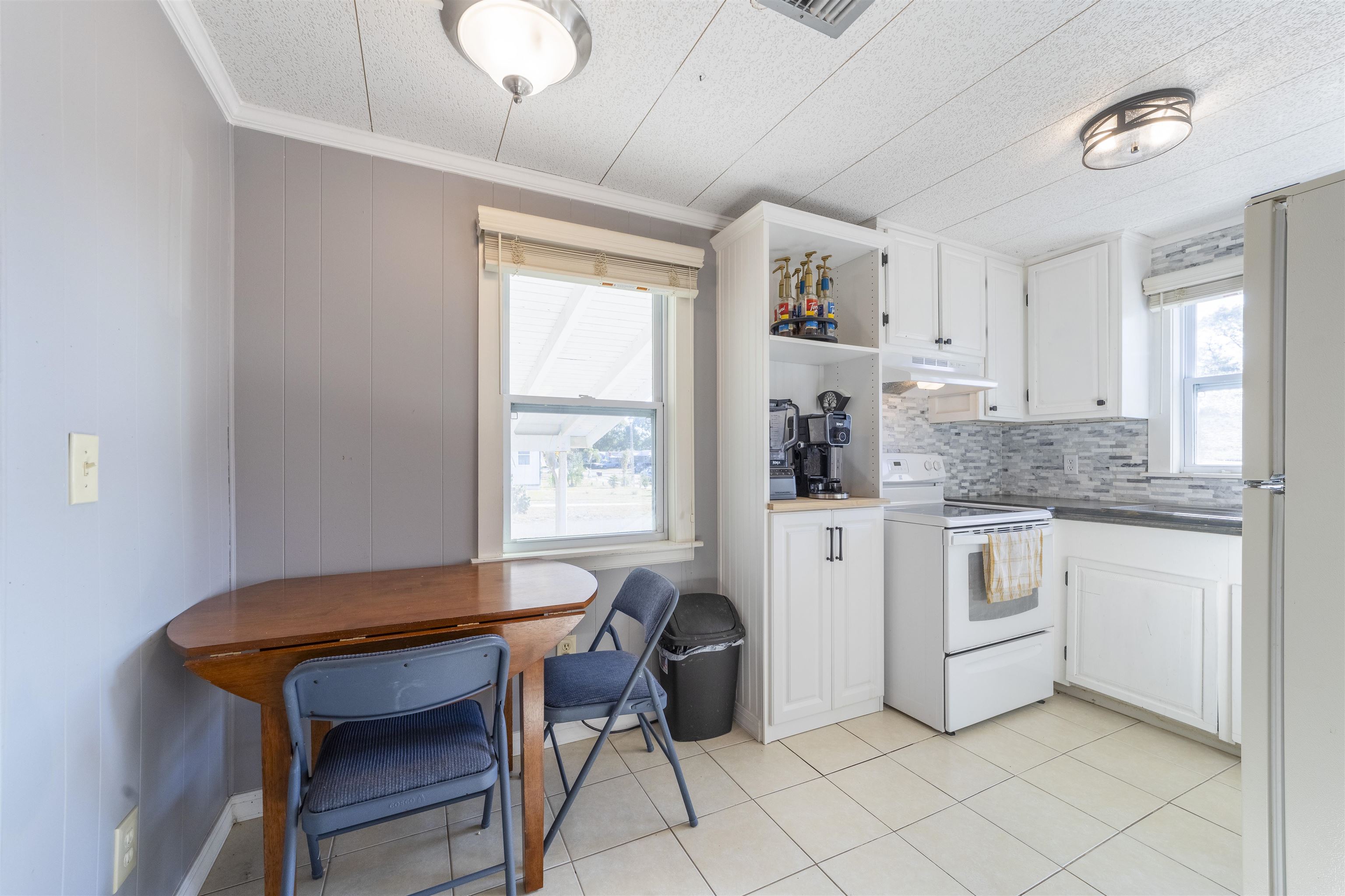 882 Palermo Road St. Augustine, FL 32086 - Photo 16 of 26 a kitchen with stainless steel appliances granite countertop a stove a sink dishwasher and white cabinets with wooden floor