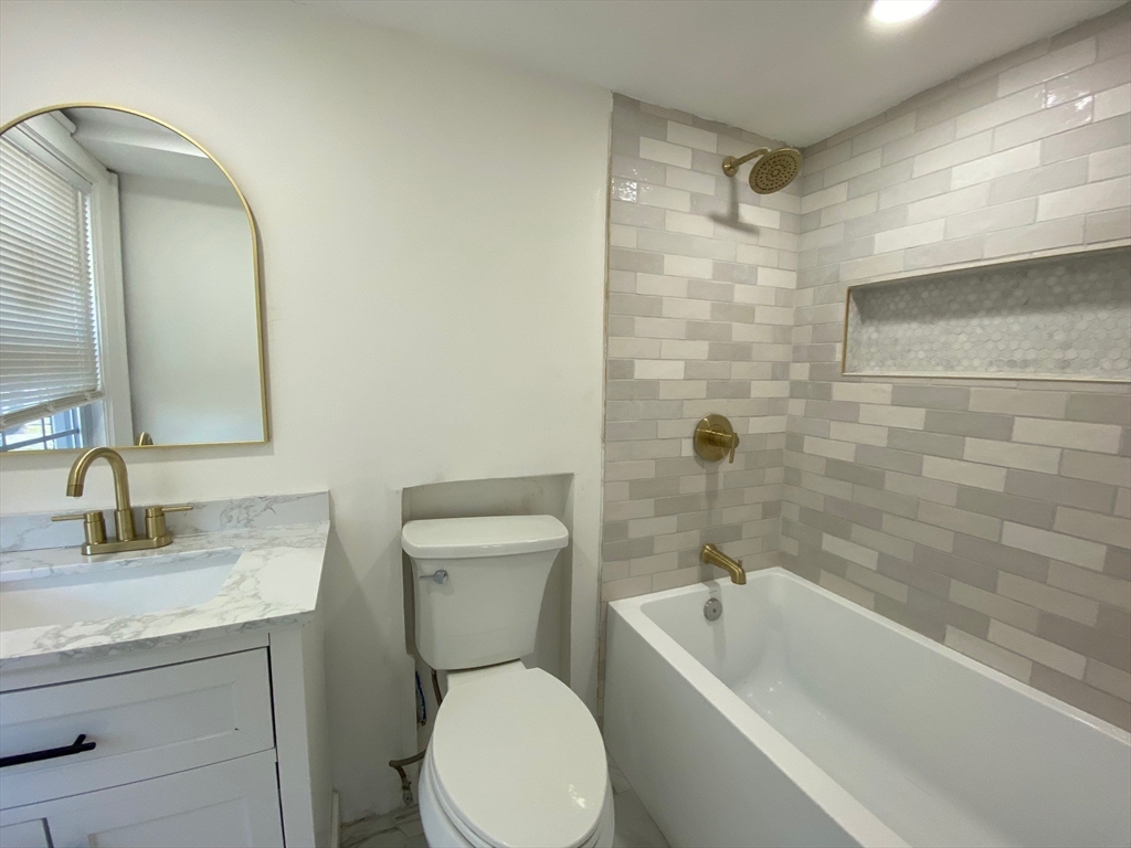 31 Freeman Terrace Springfield, MA 01104 - Photo 11 of 28 a bathroom with a granite countertop toilet a sink and bathtub