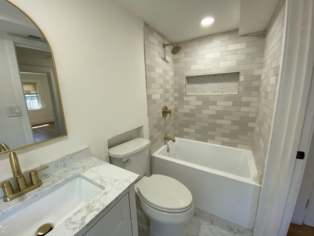 31 Freeman Terrace Springfield, MA 01104 - Photo 12 of 28 a bathroom with a granite countertop toilet a sink and bathtub