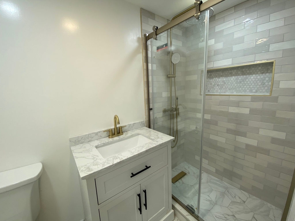 31 Freeman Terrace Springfield, MA 01104 - Photo 24 of 28 a bathroom with a granite countertop sink a toilet and shower