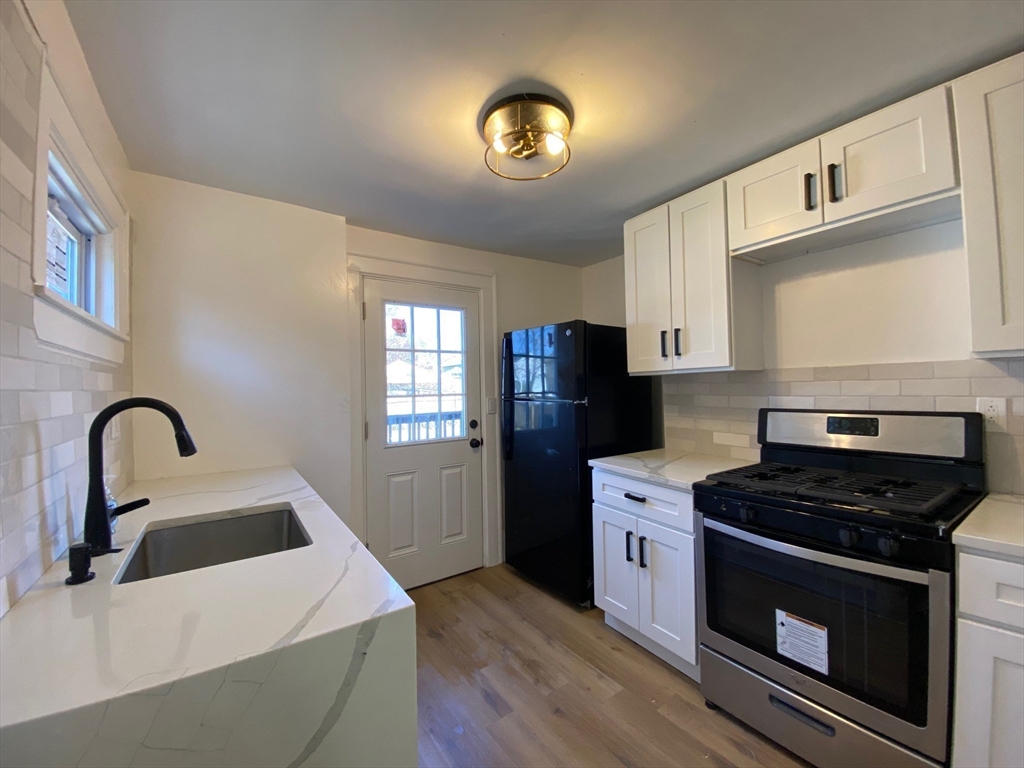 31 Freeman Terrace Springfield, MA 01104 - Photo 4 of 28 a kitchen with a stove a sink and a refrigerator