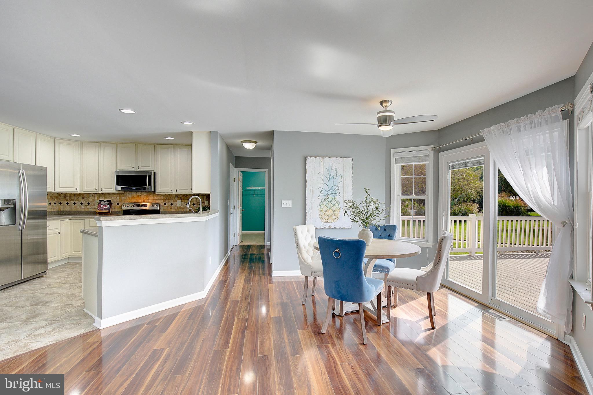 123 Bentons Pleasure Road Chester, MD 21619 - Photo 16 of 63 a kitchen with stainless steel appliances granite countertop a stove top oven a sink dishwasher a dining table and chairs with wooden floor
