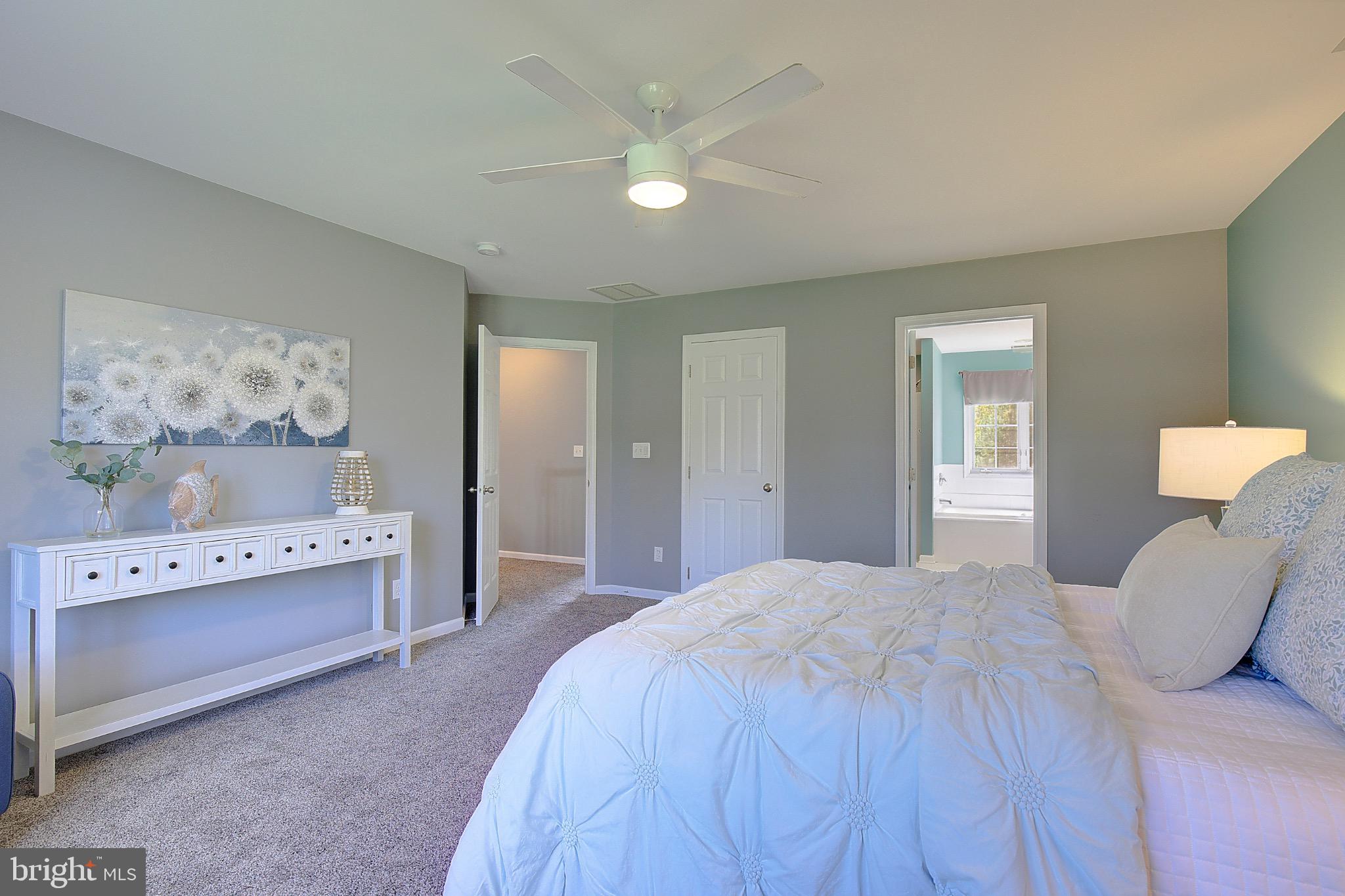 123 Bentons Pleasure Road Chester, MD 21619 - Photo 34 of 63 a spacious bedroom with a bed and a chandelier