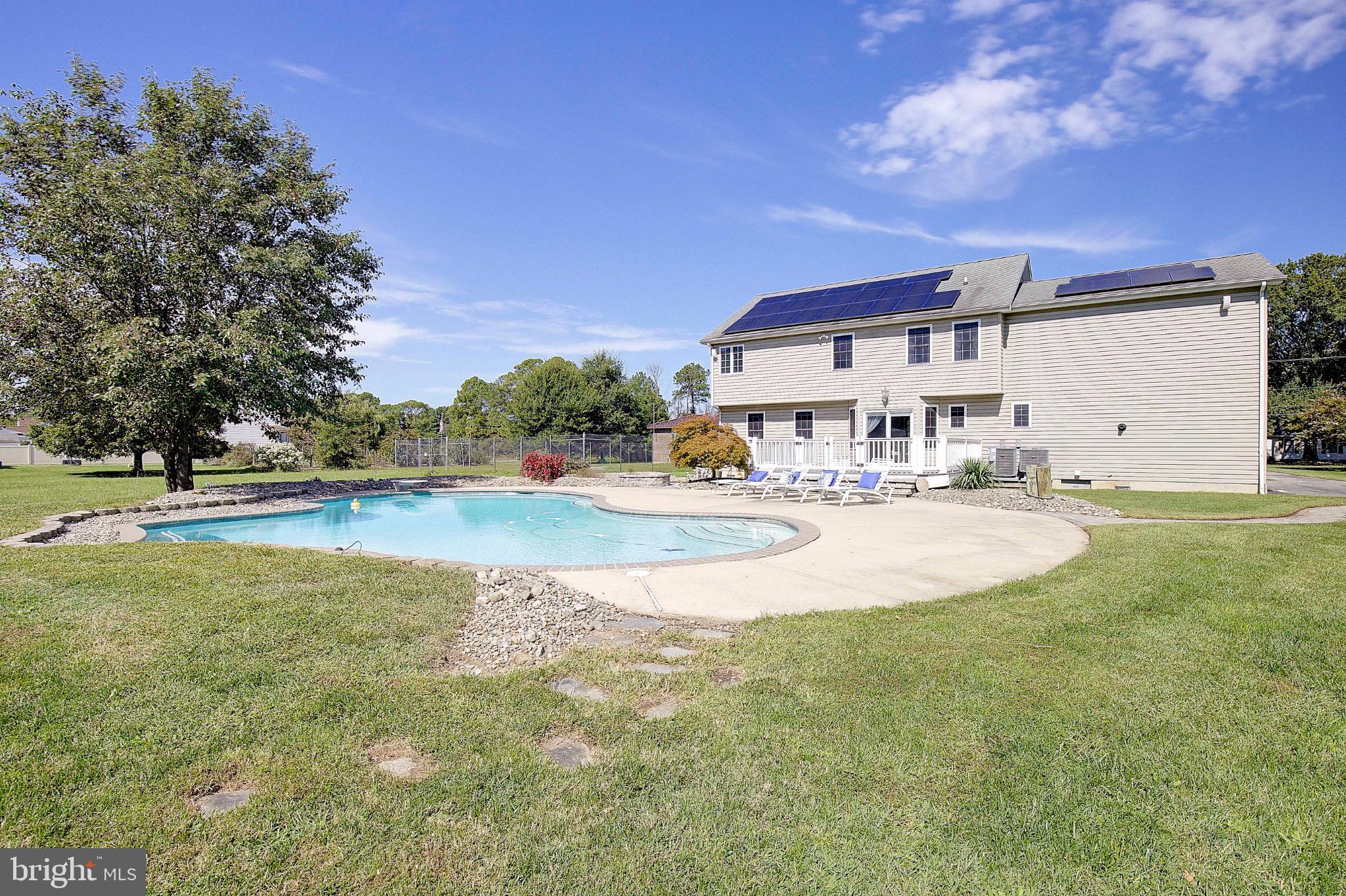 123 Bentons Pleasure Road Chester, MD 21619 - Photo 48 of 63 a view of swimming pool with outdoor seating and house in the background