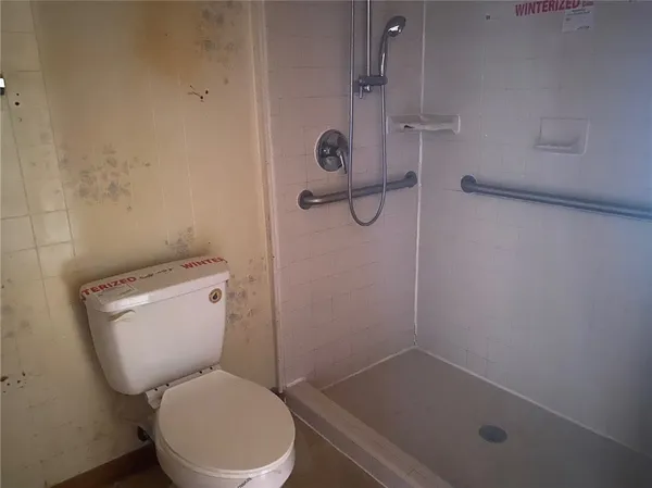 a white toilet sitting next to a bath tub