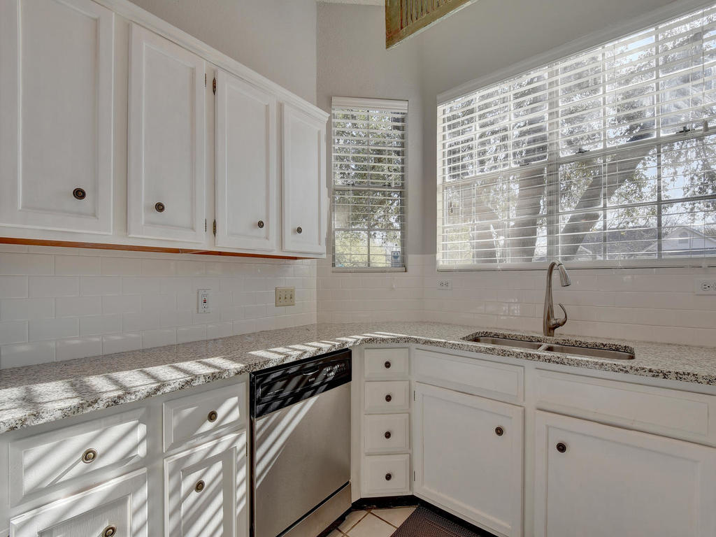 3019 Rochelle Drive Austin, TX 78748 - Photo 10 of 21 a kitchen with granite countertop white cabinets and white appliances