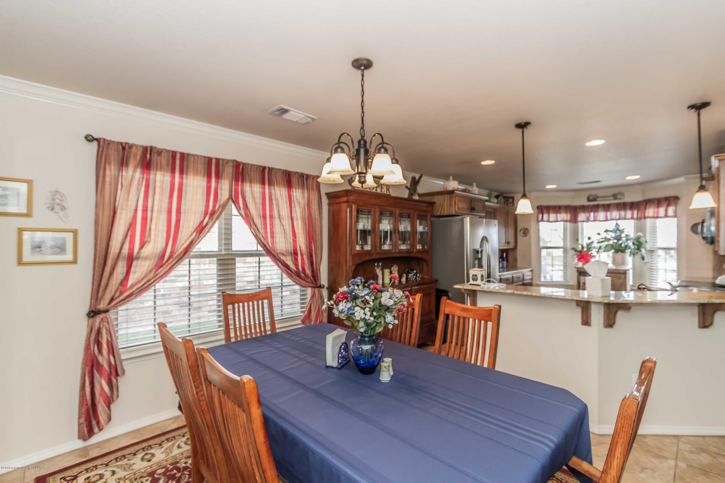 3707 Arden Road Amarillo, TX 79118 - Photo 12 of 32 a dining room with furniture a chandelier and wooden floor