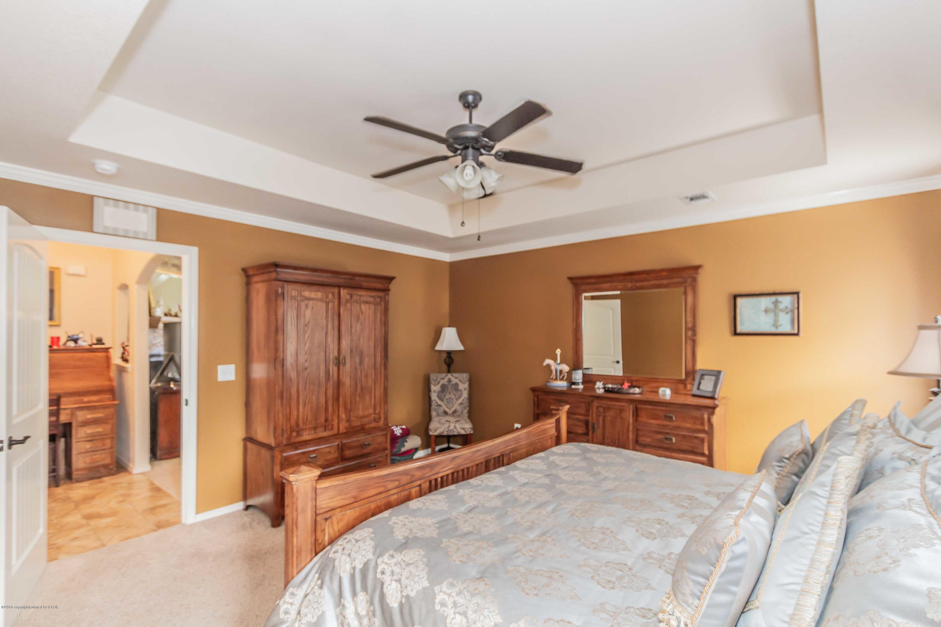 3707 Arden Road Amarillo, TX 79118 - Photo 16 of 32 a bedroom with a bed and a chandelier