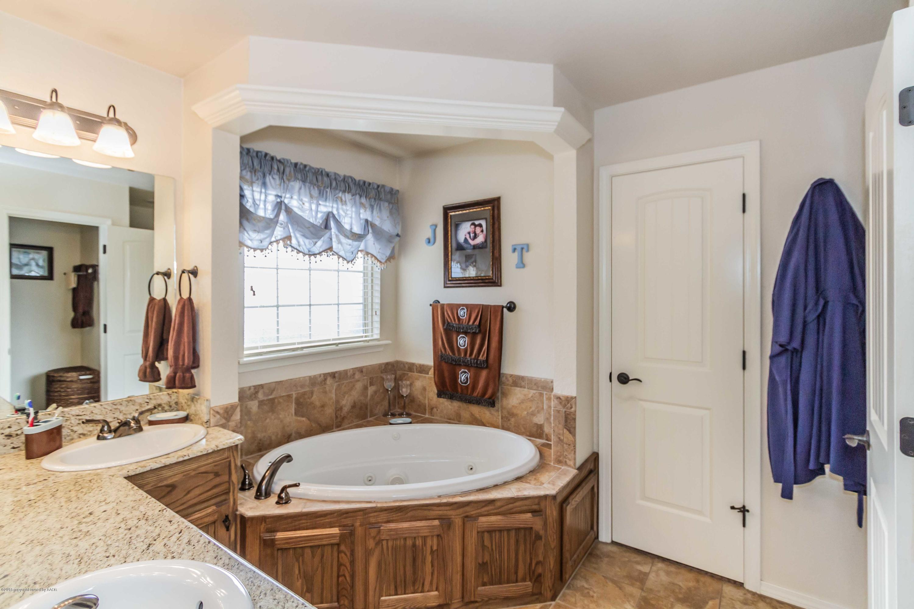3707 Arden Road Amarillo, TX 79118 - Photo 17 of 32 a bathroom with a tub a sink and a mirror