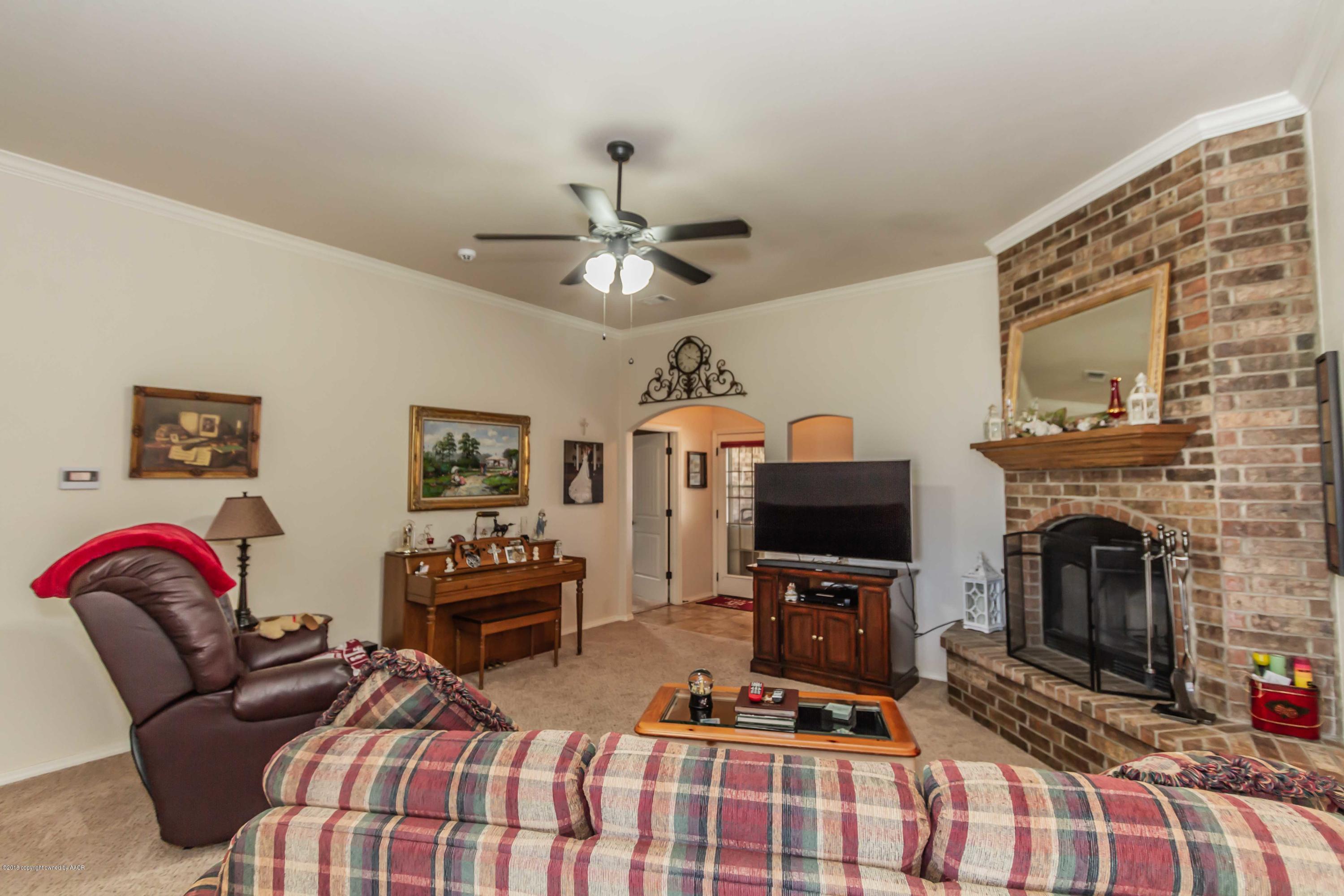 3707 Arden Road Amarillo, TX 79118 - Photo 3 of 32 a living room with furniture a flat screen tv and a fireplace