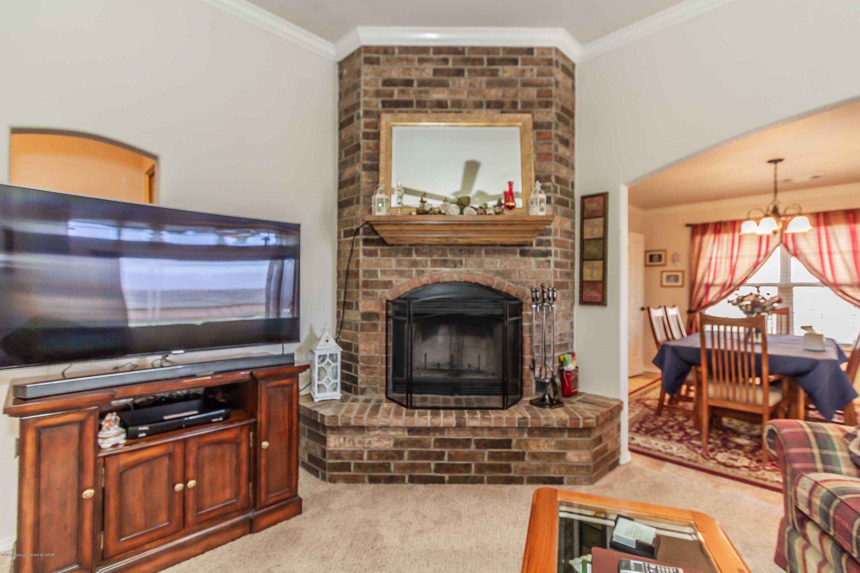 3707 Arden Road Amarillo, TX 79118 - Photo 4 of 32 a living room with furniture a flat screen tv and a fireplace
