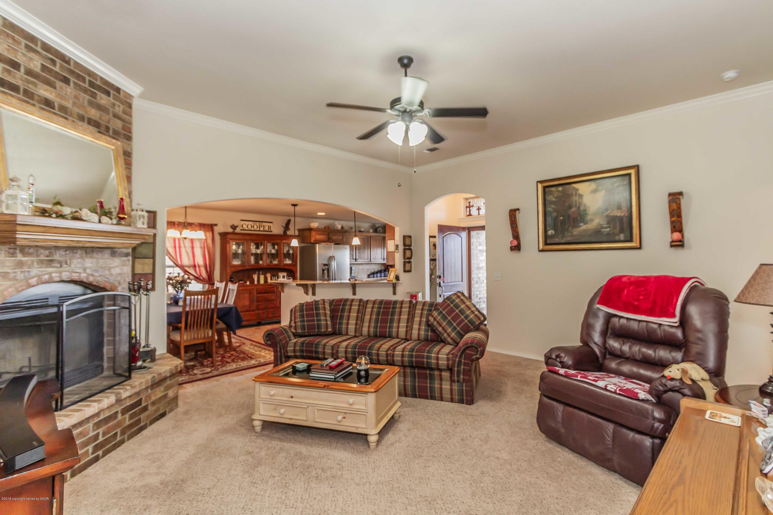 3707 Arden Road Amarillo, TX 79118 - Photo 5 of 32 a living room with furniture a flat screen tv and a fireplace