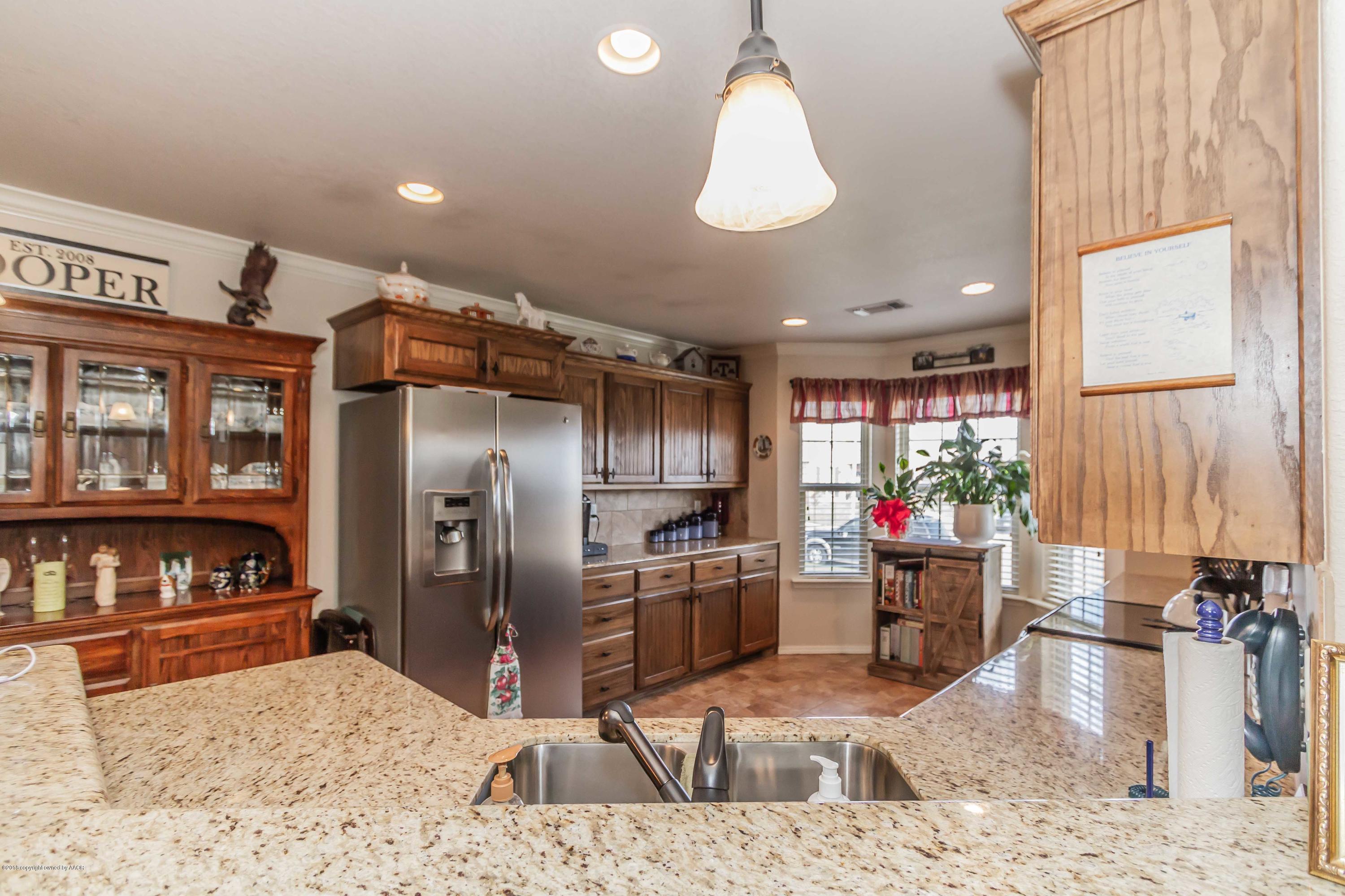 3707 Arden Road Amarillo, TX 79118 - Photo 6 of 32 a kitchen with stainless steel appliances kitchen island granite countertop a refrigerator oven stove a sink and dishwasher
