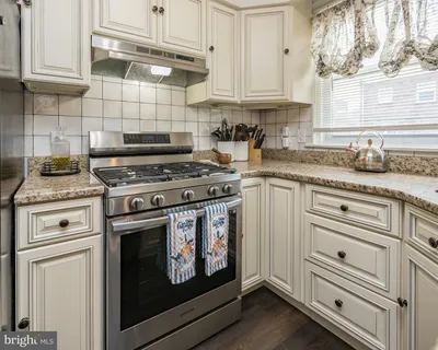 a kitchen with granite countertop white cabinets and appliances