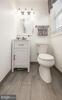 a bathroom with a sink toilet and a mirror