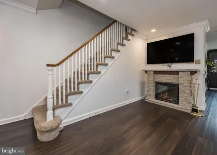 a living room with wooden floor and a fireplace