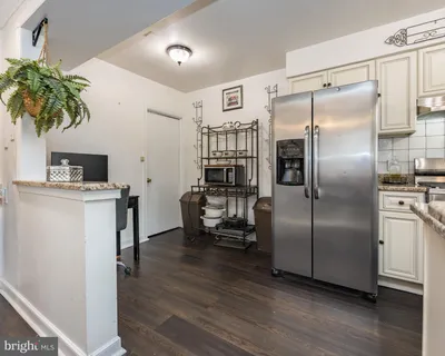 a kitchen with kitchen island a counter top space a sink stainless steel appliances and cabinets