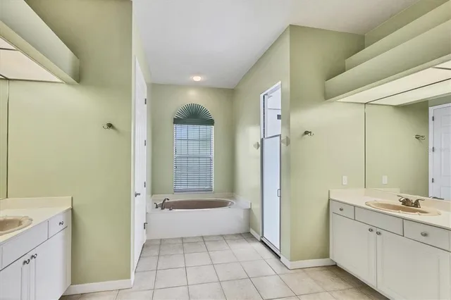 a bathroom with a granite countertop sink a mirror and a bathtub