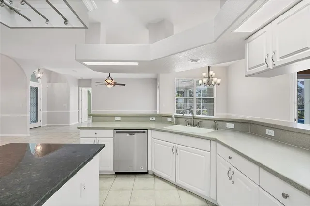 a kitchen with a sink dishwasher a stove with cabinets and potted plant
