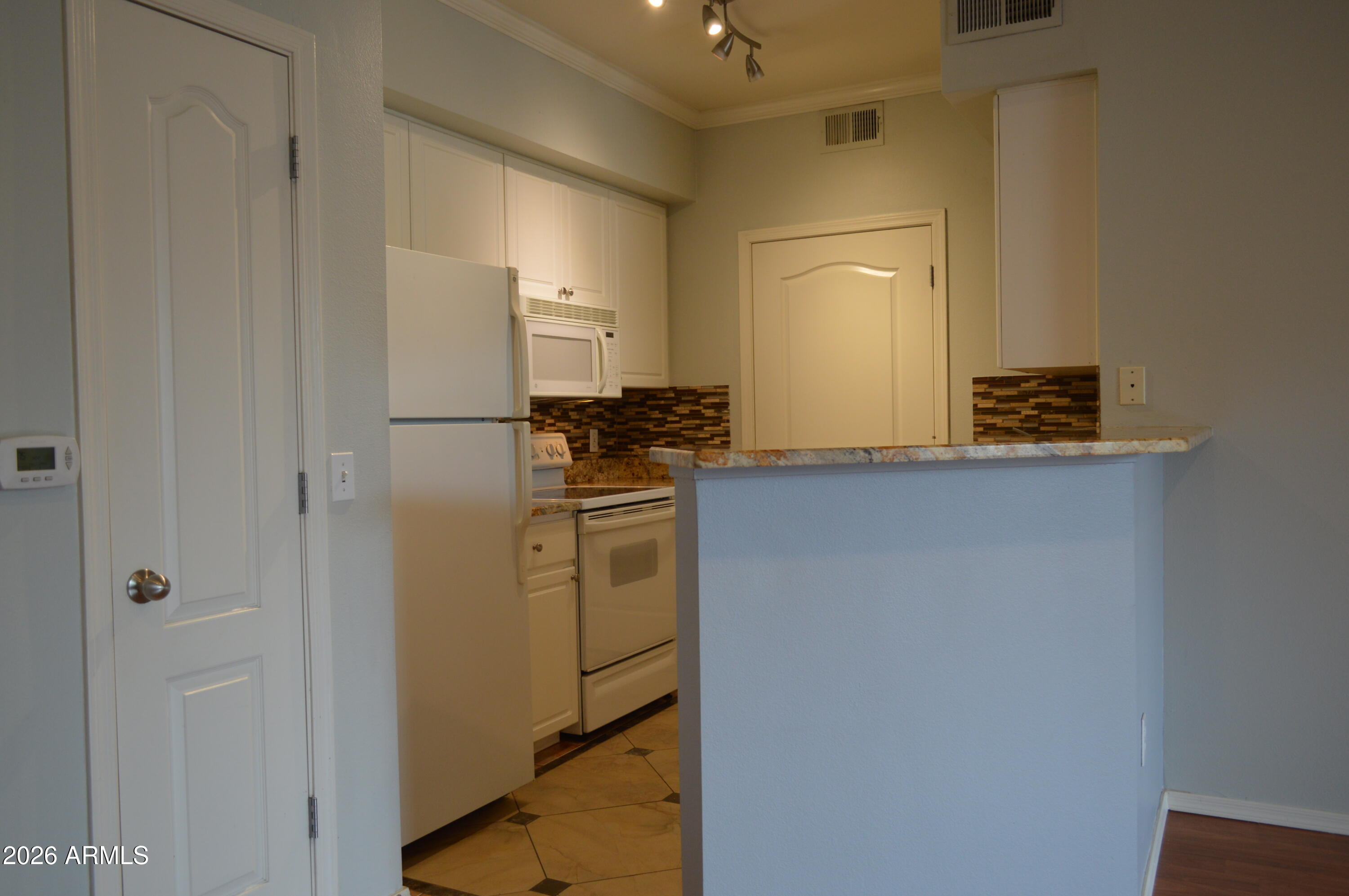 1701 East Colter Street, Unit 308 Phoenix, AZ 85016 - Photo 4 of 67 a kitchen with a refrigerator and cabinets