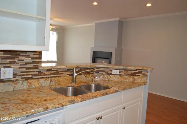 a bathroom with a granite countertop sink and washing machine