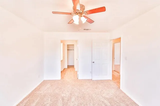 a view of a big room with chandelier fan and a window