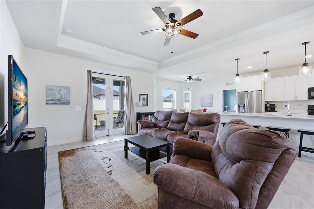 2168 Southwest 245th Terrace Newberry, FL 32669 - Photo 12 of 34 a living room with furniture a ceiling fan and a flat screen tv