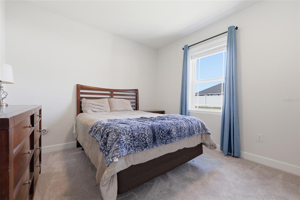 2168 Southwest 245th Terrace Newberry, FL 32669 - Photo 20 of 34 a bedroom with a bed lamp and a mirror