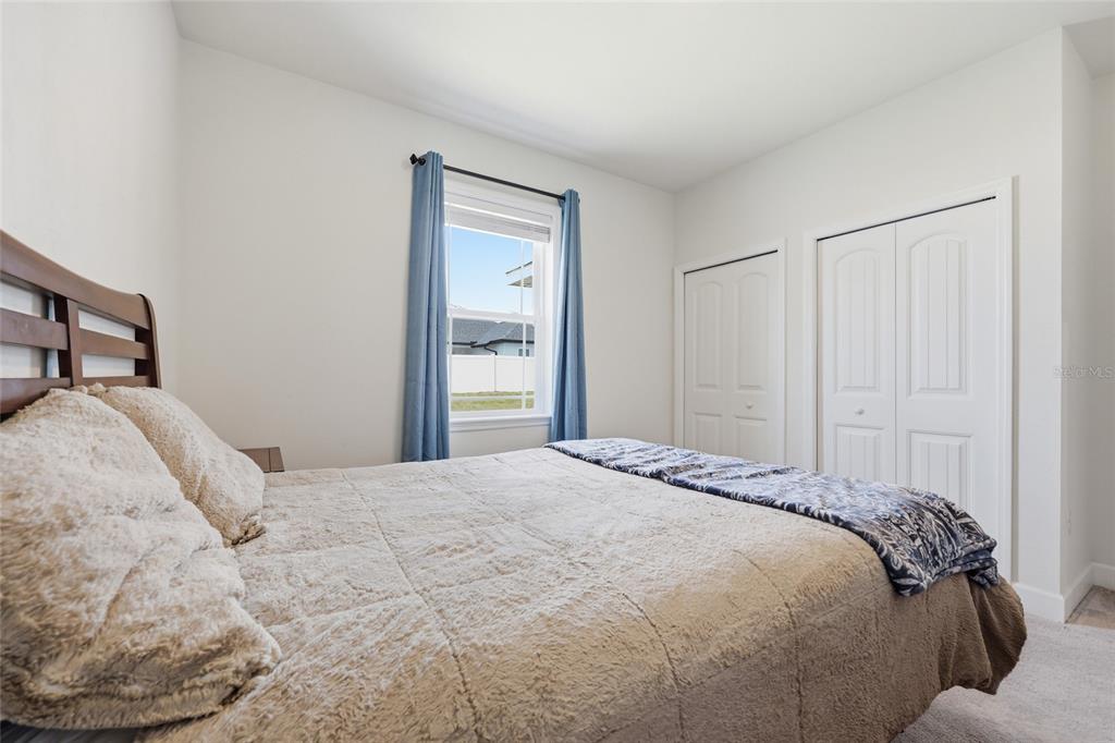 2168 Southwest 245th Terrace Newberry, FL 32669 - Photo 21 of 34 a bedroom with a bed and a mirror