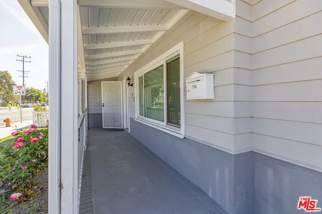 a view of a house with a small yard and wooden fence
