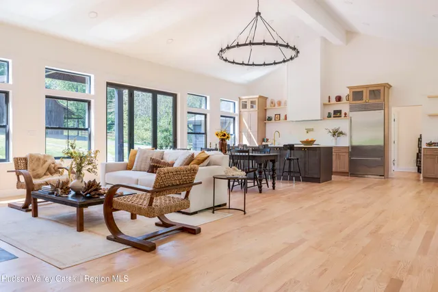 a living room with furniture and a dining table with kitchen view