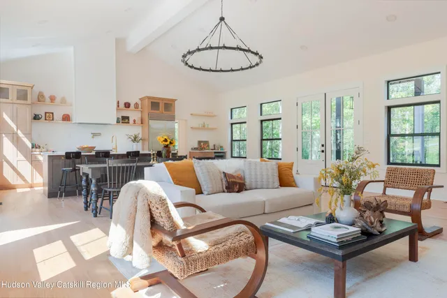 a living room with furniture kitchen view and a large window