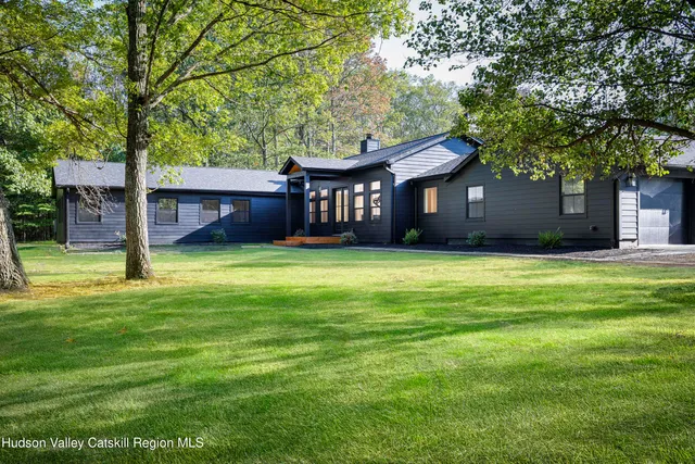 a front view of a house with yard and green space