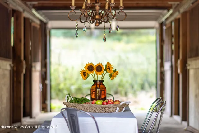 a view of a dining room with furniture a chandelier and window