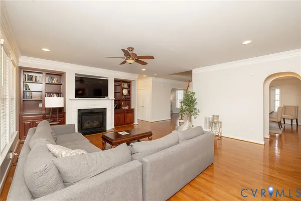 a living room with granite countertop lots of white furniture and chandelier