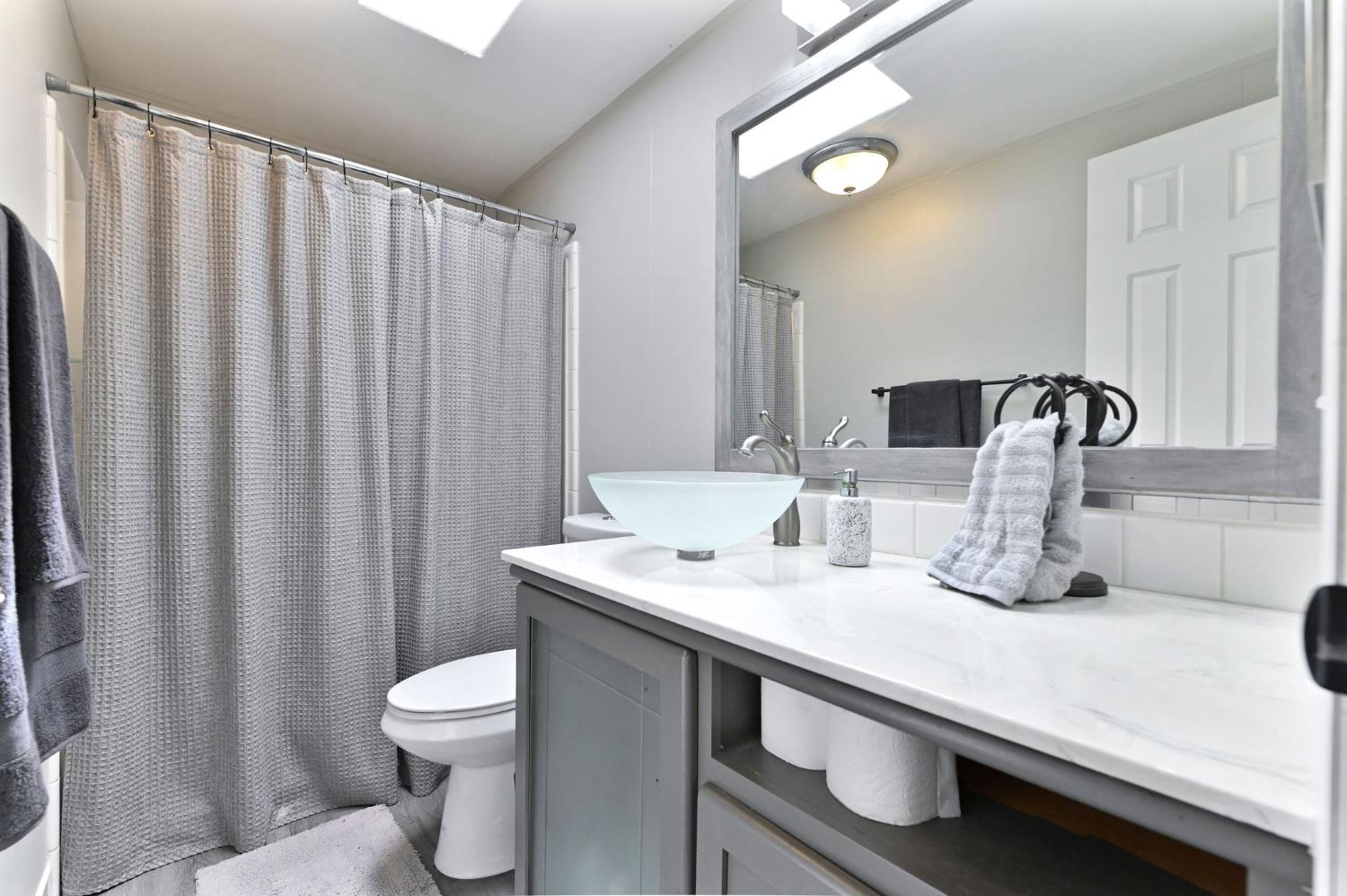 5695 Old Emigrant Trail Mountain Ranch, CA 95246 - Photo 13 of 79 a bathroom with a sink a toilet and shower curtain