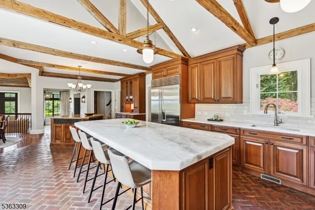 a kitchen with a stove a sink cabinets and wooden floor