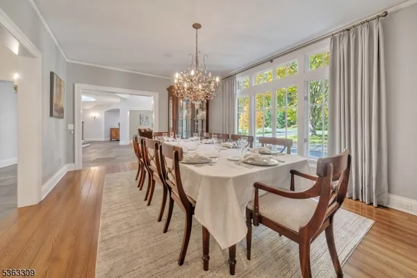 a dining room with furniture a chandelier and wooden floor